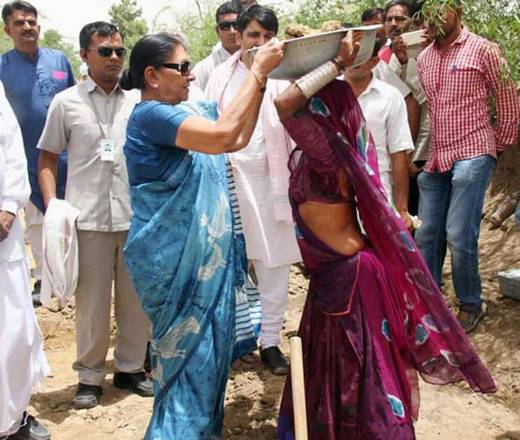 Gujarat Chief Minister Anandiben Patel helps a woman labourer at a work site during a visit to drought-hit Dantiwada in north Gujarat.
