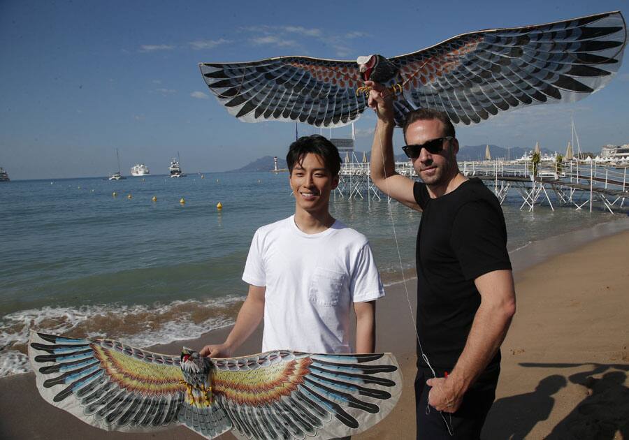 Actors Joseph Fiennes, right, and Simon Twu fly Chinese kites during a photo call for the film The Last Race at the 69th international film festival, Cannes.
