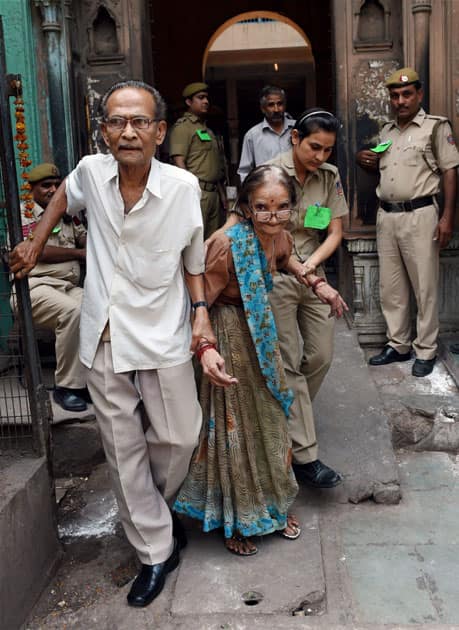 An elderly couple is helped near a polling booth in Ballimaran Ward during MCD by-elections in New Delhi.