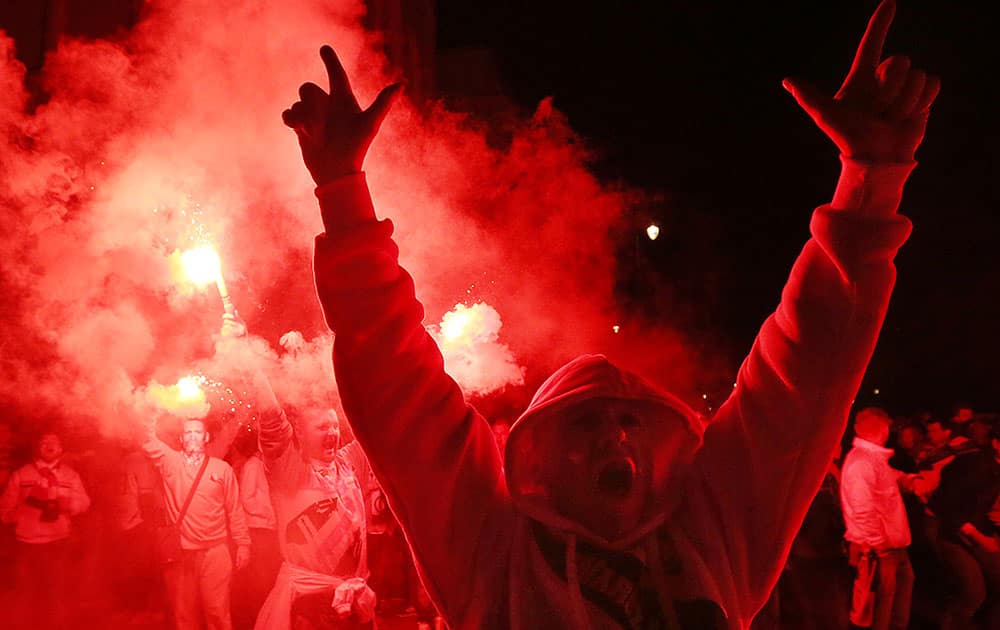 Fans of Warsaw's soccer team Legia Warszawa burn flares as they celebrate their club's victory of the Polish soccer championship in old town in Warsaw, Poland.