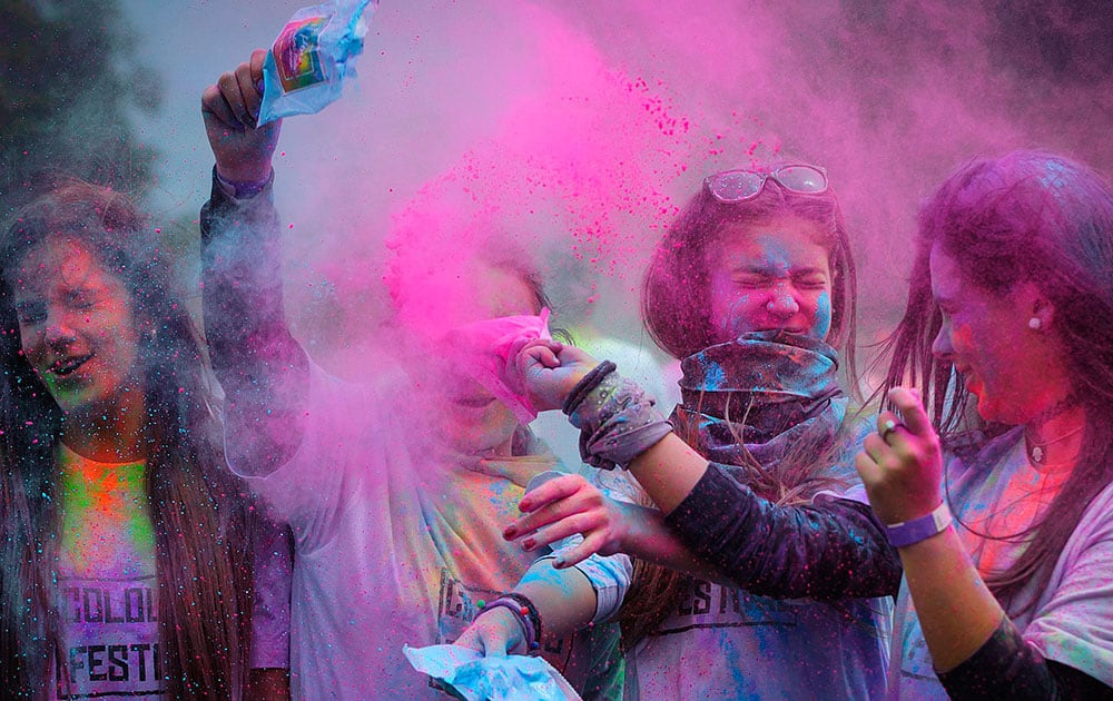 Festival goers throw powdered paint during the Festival of Colours in the city of Oradea, Western Romania.