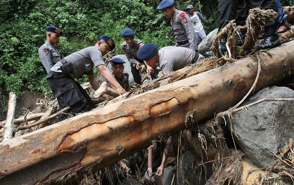 Rescuers recover the body of a victim after a flood hit Dua Warna waterfall in Sibolangit, North Sumatra, Indonesia.