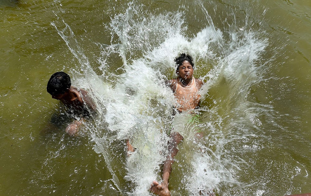 Children enjoy in the waters at a fountain to beat the heat at India Gate as the mercury rises in New Delhi.