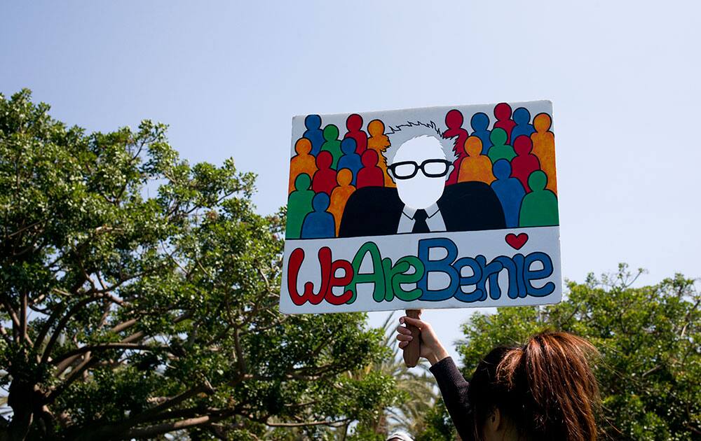 Hsingii Bird holds up a sign for supporters to take a selfie with it before a campaign rally with Democratic presidential candidate Sen. Bernie Sanders, I-Vt.