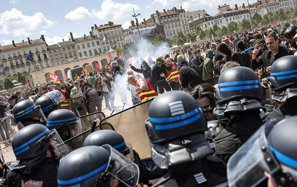 People face riot police during a protest in Lyon, central France.