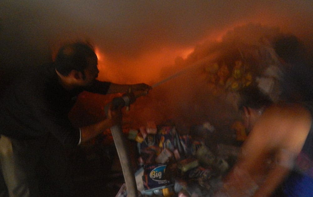 A fire fighter dousing the fire that broke out at a transport company in Jalandhar.