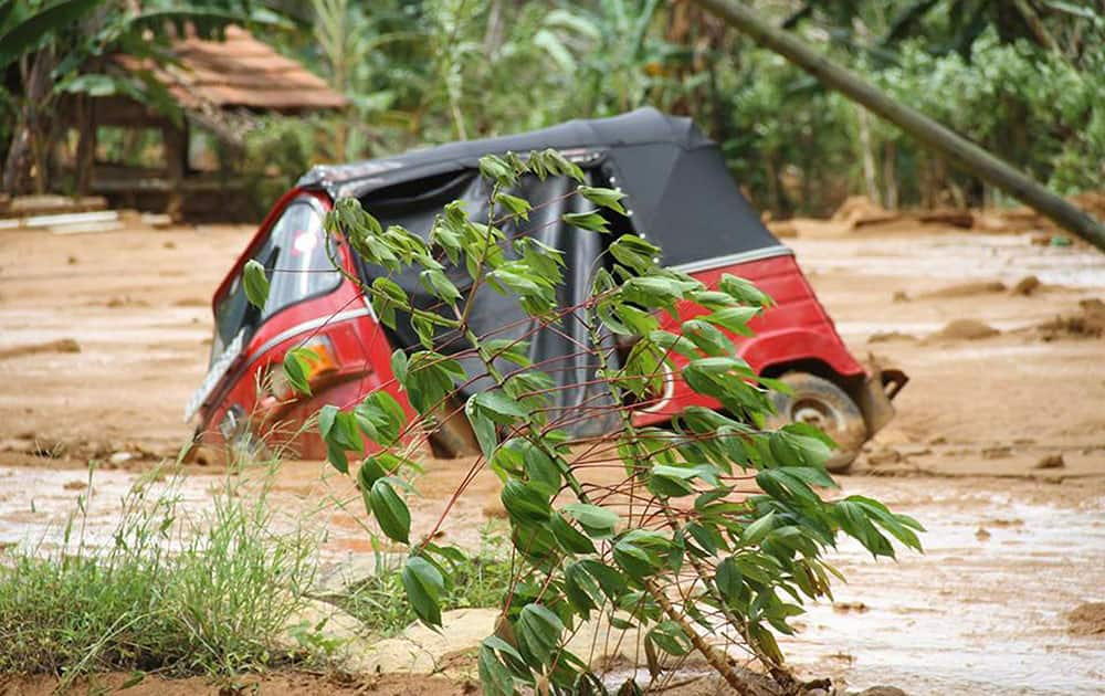 This photograph provided by Sri Lankan Red Cross shows an autorickshaw, a three wheeler vehicle partially submerged in mud after a massive landslide at Aranayaka in Kegalle District, about 72 kilometers (45 miles) north of Colombo, Sri Lanka.
