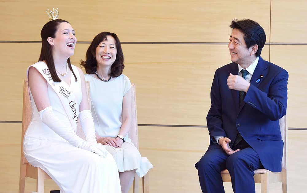 U.S. Cherry Blossom Queen Reichel Bohn, left, chats with Japanese Prime Minister Shinzo Abe, right, as she pays a courtesy call at Abes official residence in Tokyo.