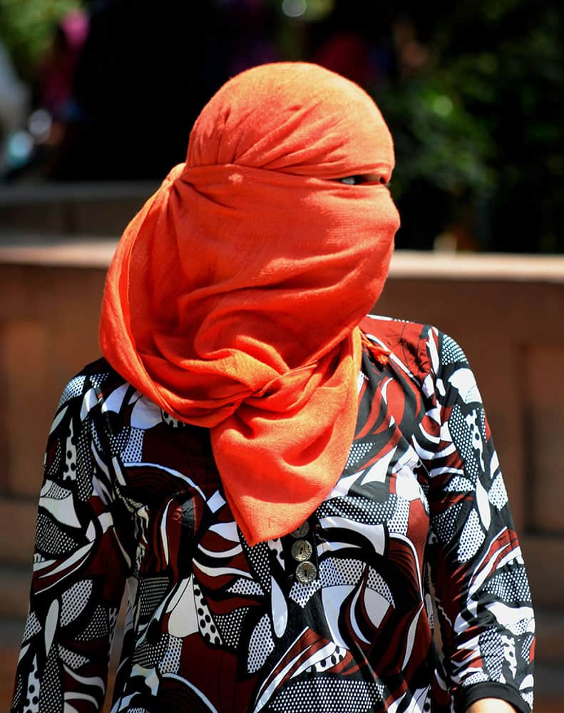 A girl covers her face with scarf to get respite from heat on a hot day in Amritsar.