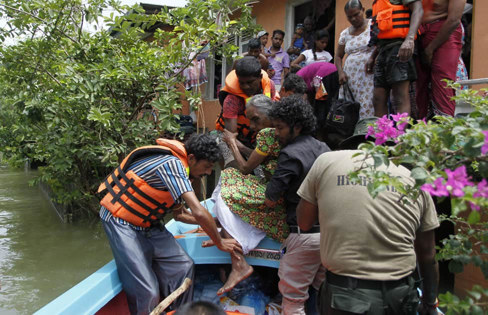 Sri Lankan relief workers evacuate a stranded family from their submerged house in a flooded area of Wellampitiya on the out skirts of Colombo, Sri Lanka.