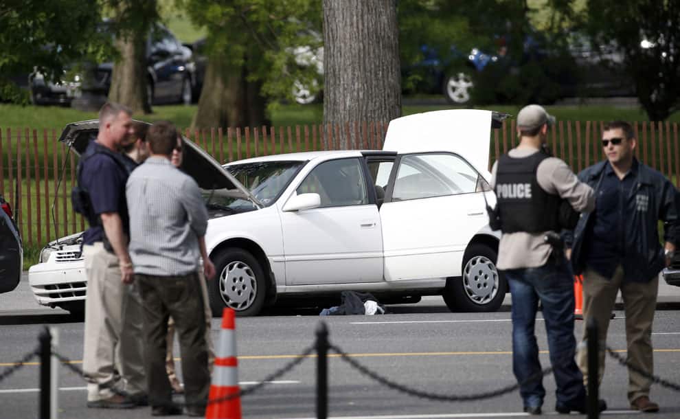 A Toyota sedan with its doors, hood and trunk open is parked on Constitution Avenue in Washington, after a Secret Service agent shot a man with a gun who approached a checkpoint outside the White House and refused to drop his weapon.