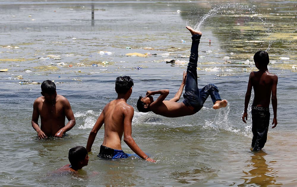 children play in the Sabarmati river to beat the heat on a hot summer day in Ahmedabad.