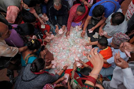 Nepalese devotees get their money changed to smaller denomination to offer them in alms to Buddhist monks during Buddha Jayanti, or Buddha Purnima festival in Kathmandu, Nepal.
