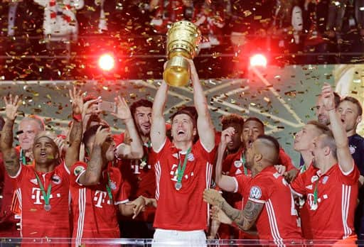 Bayern's Robert Lewandowski holds up the trophy after the German soccer cup final match between Borussia Dortmund and FC Bayern Munich in Berlin, Germany.