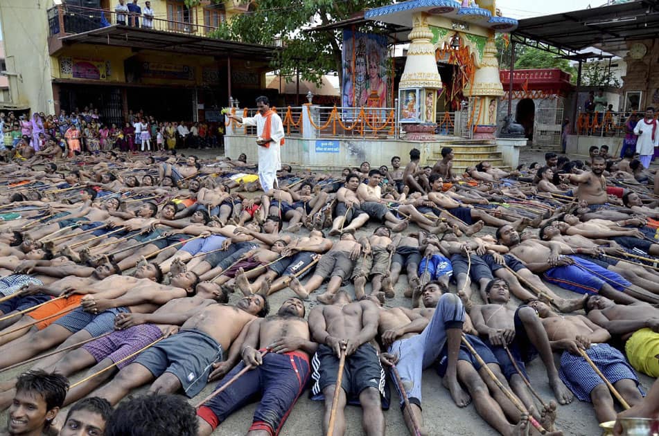 Farmers lie on the ground with sticks as they pray for rain during the Manda Festival at a temple on the outskirts of Ranchi.
