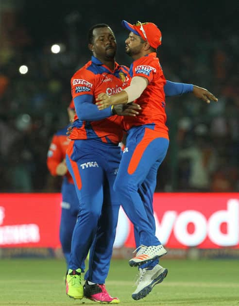 Gujarat Lions player Dwayne Smith and Gujarat Lions captain Suresh Raina celebrates the wicket of Mumbai Indians player Martin Guptill during an IPL match against Mumbai Indians at Green Park in Kanpur.