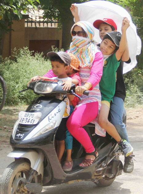 People cover their faces to protect themselves from scorching heat on a very Hot Day in Allahabad.
