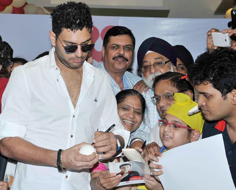 Cricketer Yuvraj Singh gives autographs to his fans during an event in Kolkata.
