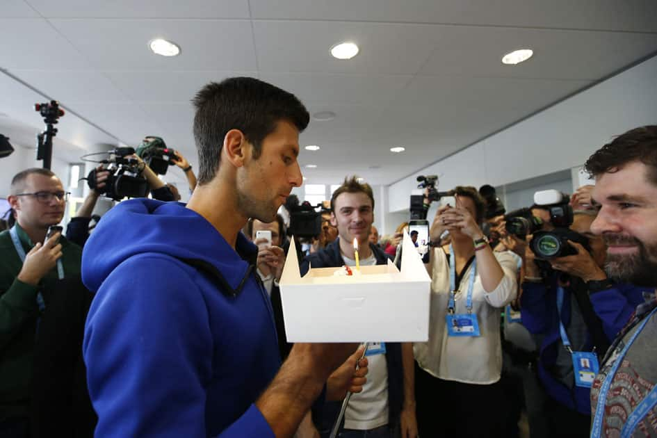 Paris : Serbias Novak Djokovic blows a candle on a birthday cake at the Roland Garros stadium.