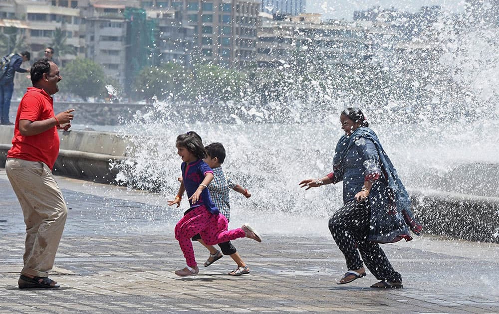 People enjoy a high tide at the Marine drive in Mumbai.
