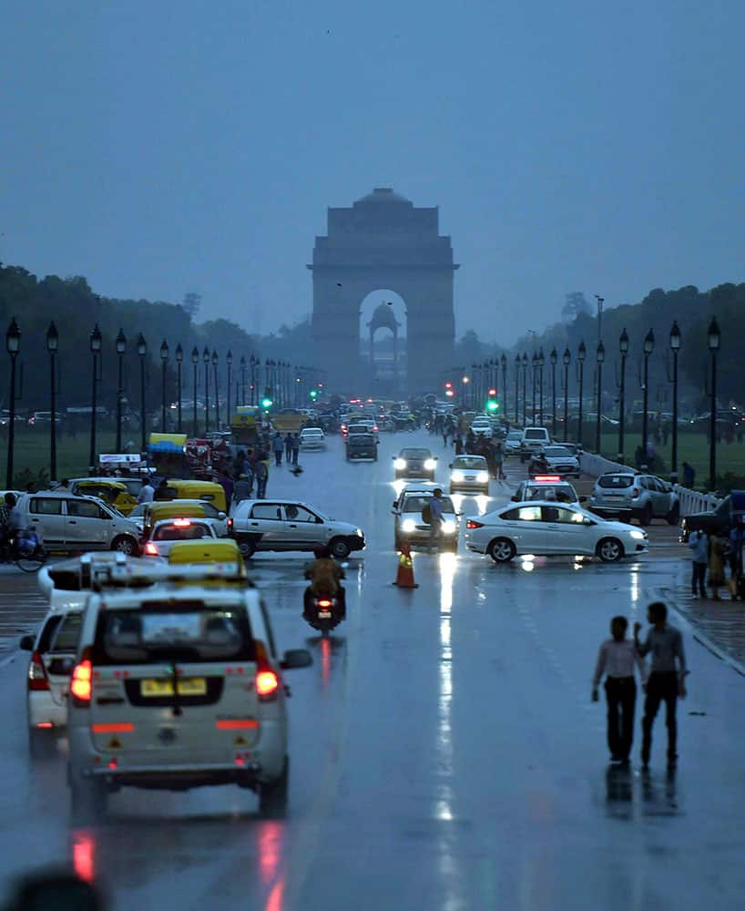Vehicles move on Rajpath during rain in New Delhi.