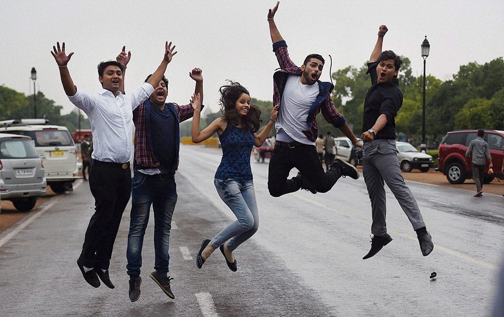 Youngsters enjoy in the rains in New Delhi.