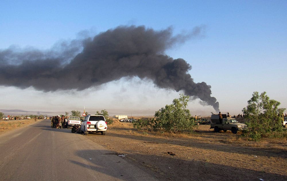 Smoke rises from Islamic State group positions after an airstrike by U.S.-led coalition warplanes in Fallujah, as Iraqi security forces and allied Shiite Popular Mobilization Forces and Sunni tribal fighters, take combat positions outside Fallujah, 40 miles (65 kilometers) west of Baghdad, Iraq.