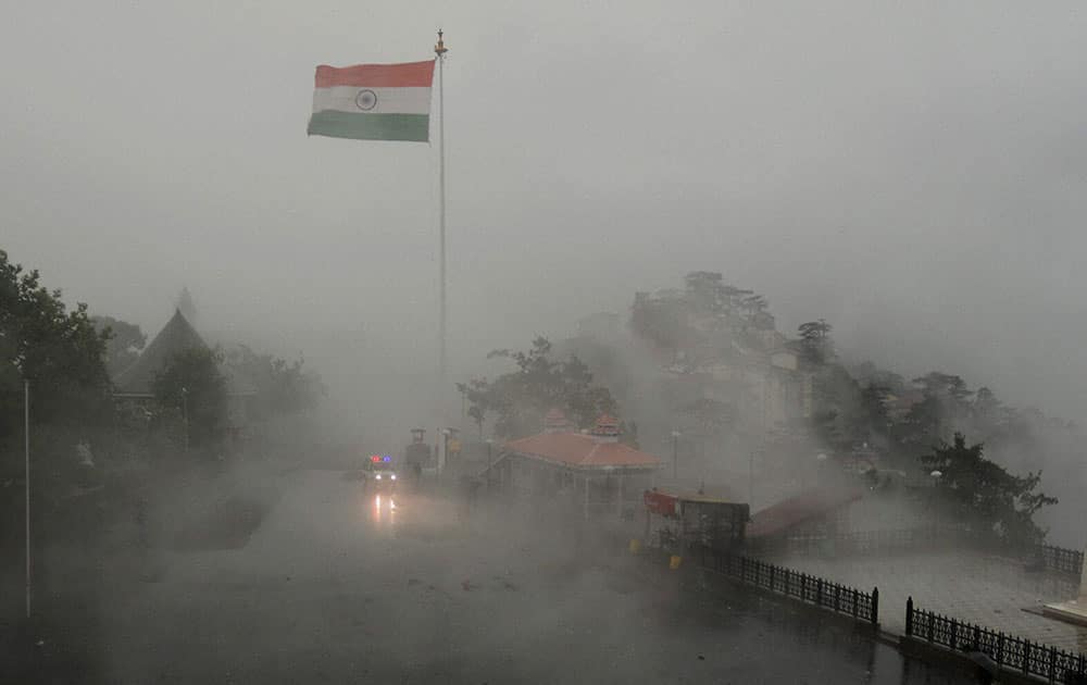 Ambulance moves slowly during rainfall in the northern hill town of Shimla.