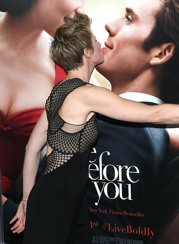 Director Thea Sharrock kisses a poster of Sam Claflin and Emilia Clarke at the world premiere of 