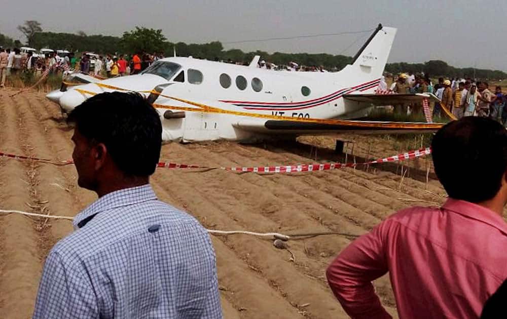 People watching the air ambulance which crash landed at Kair village in Najafgarh area of Delhi. Seven people including a patient were on board during the mishap.