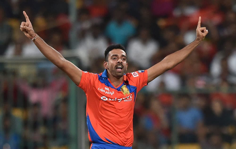 Gujarat Lions bowler Dhawal Kulkarni celebrates the wicket of Chris Gayle during the 1st qualifier IPL 2016 match against Royal Challengers Bangalore at Chinnaswamy Stadium in Bengaluru.