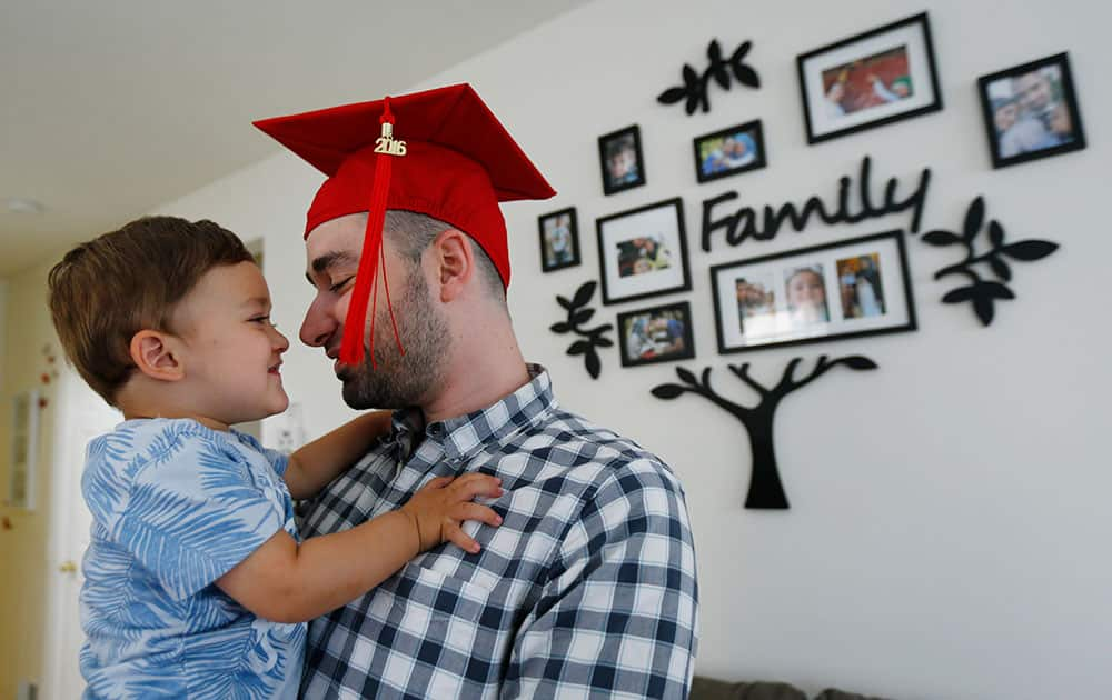 Mohamad Bassel Khair, right, kisses his 2-year-old son Sami Khair between a photo shoot with The Associated Press in his home in Clifton, N.J. Khair, of Damascus, Syria, is graduating from Montclair State University with a master’s degree in nutrition and food science. 