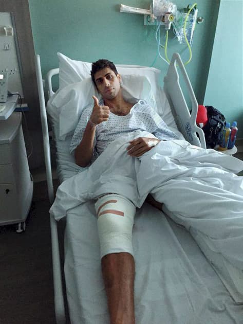 Seamer Ashish Nehra gestures after undergoing a surgery on his right knee in London.
