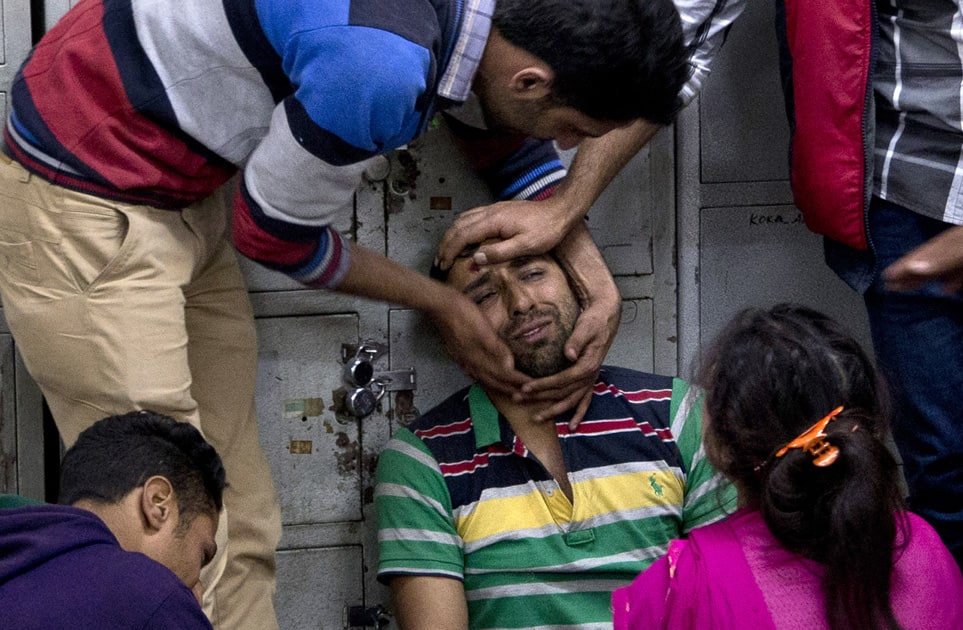 ashmiri civilians comfort wailing relative of Riyaz Ahmad Ganie, a policeman killed in a rebel attack, in Srinagar.
