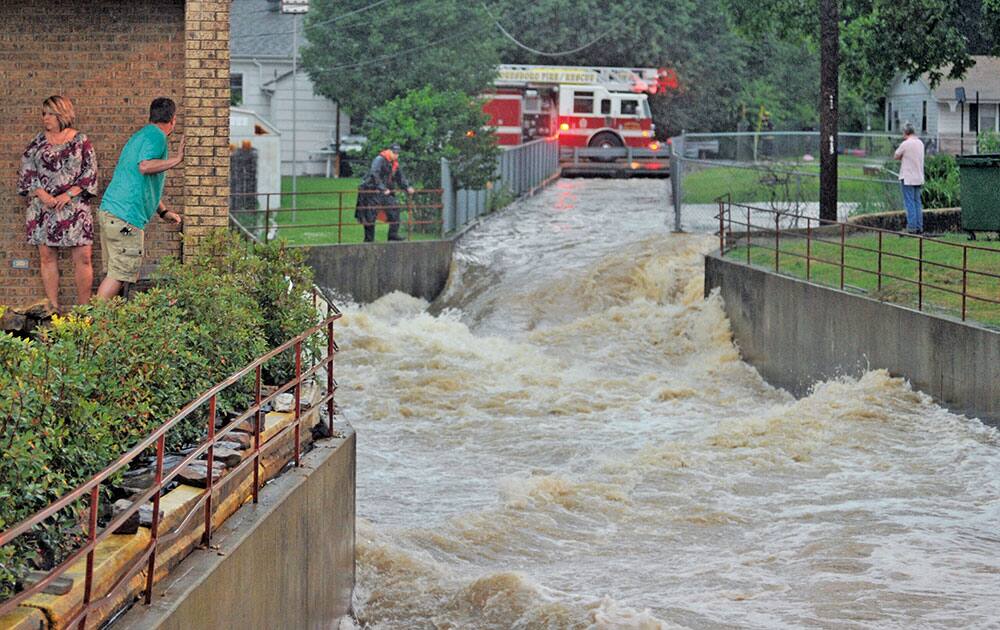 Officials and residents search for a boy who went missing Tuesday, May 24, 2016, in Jonesboro, Ark. The teenager was found safe hours later near the intersection of Culberhouse Street and Sims Avenue, not far from where he was reported missing. More than 5 inches of rain fell in about four hours Tuesday afternoon in Jonesboro. 