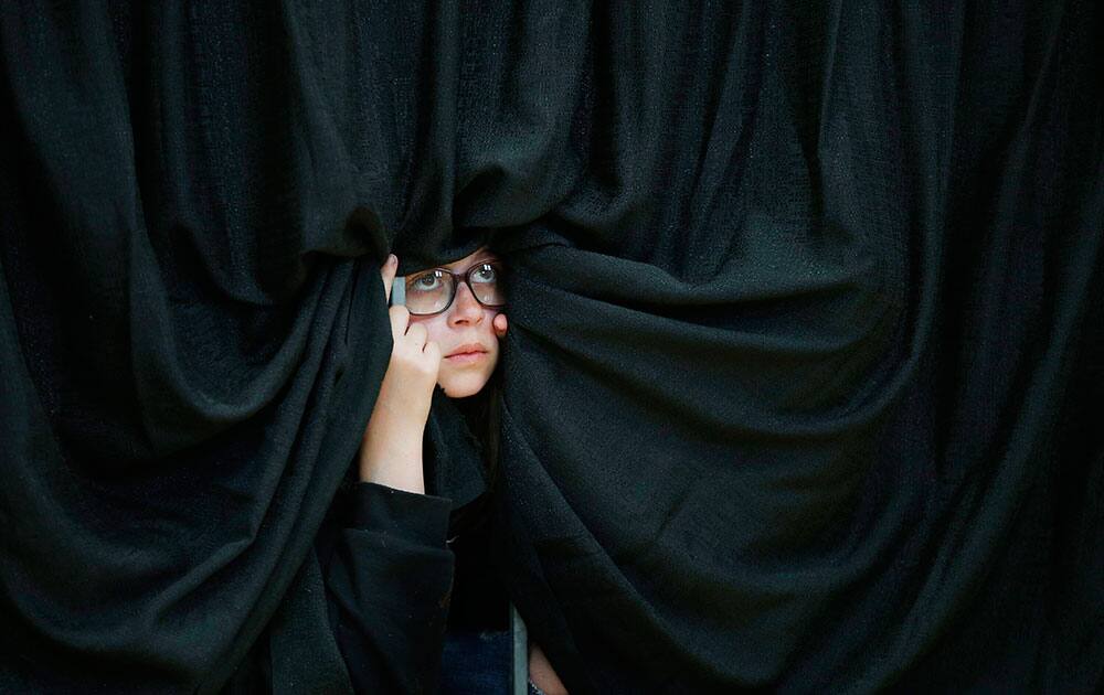 A girl watches Democratic presidential candidate Hillary Clinton speak at a rally at Hartnell College in Salinas, Calif.