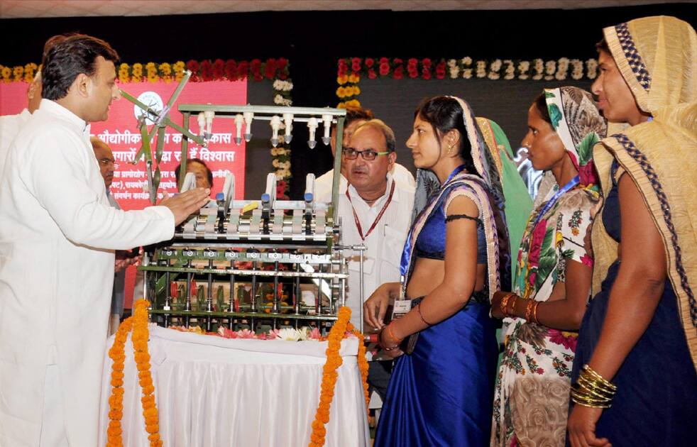 Uttar Pradesh Chief MInister Akhilesh Yadav providing charkhas (mini looms) to women of drought-hit Bundelkhand region during a function to promote Khadi products at CMs residence in Lucknow.