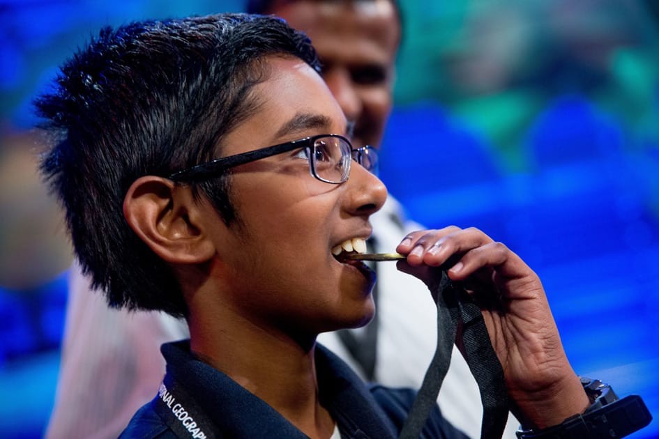 Rishi Nair of Florida bites his metal after winning the 2016 National Geographic Bee.