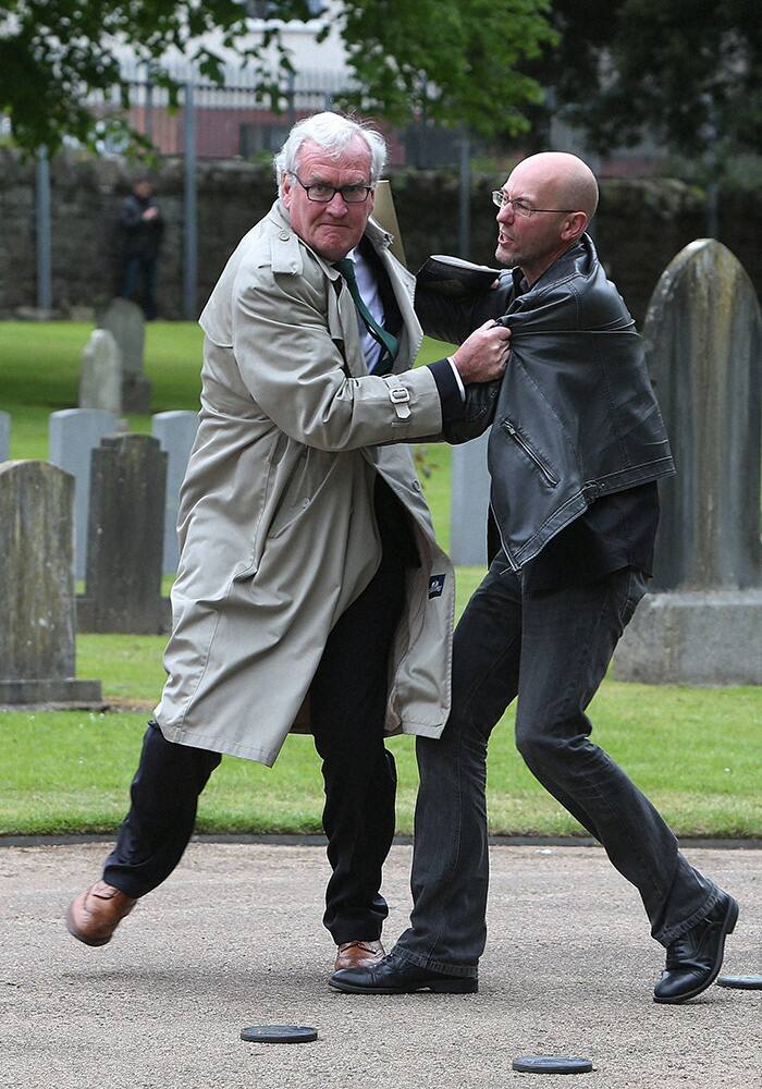 Canadian Ambassador to Ireland Kevin Vickers, left, wrestles with a protester during a State ceremony to remember the British soldiers who died during the Easter Rising at Grangegorman Military Cemetery, Dublin.