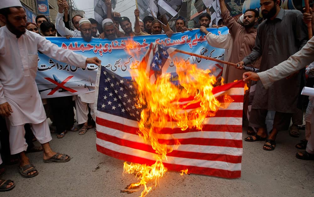 Supporters of Pakistani religious group Jamaat-ud-Dawa burn representation of an American flag during a protest rally to condemn the US drone strike in Pakistani territory which killed Taliban leader Mullah Mansour.