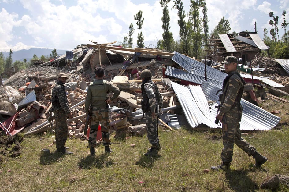 Indian security personnel inspect the site of a gunbattle with rebels in Khonshipora, 40 kilometers (25 miles) west of Srinagar.