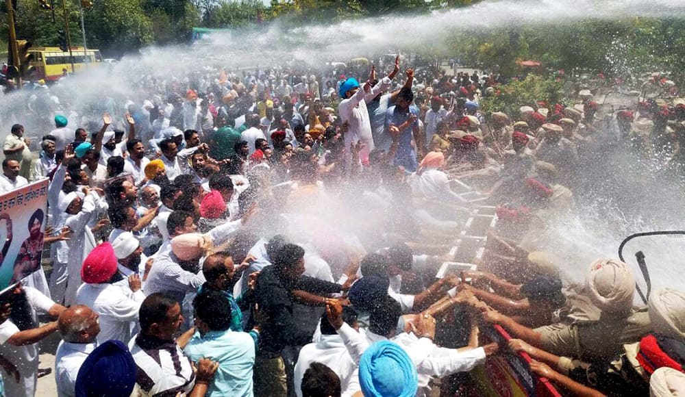Police use water cannon to disperse Congress members during a protest in Ludhiana.
