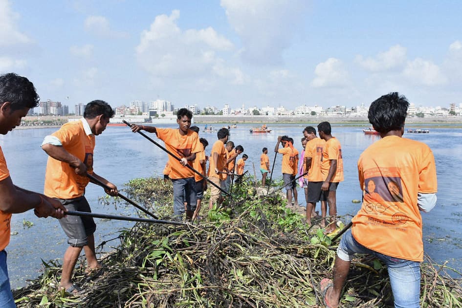 Volunteers clean Tapi river to celebrate the completion of two years of Modi government, in Surat.
