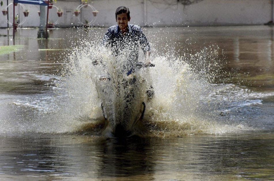 A motorcyclist wades at a waterlogged road after heavy rains in Patna.
