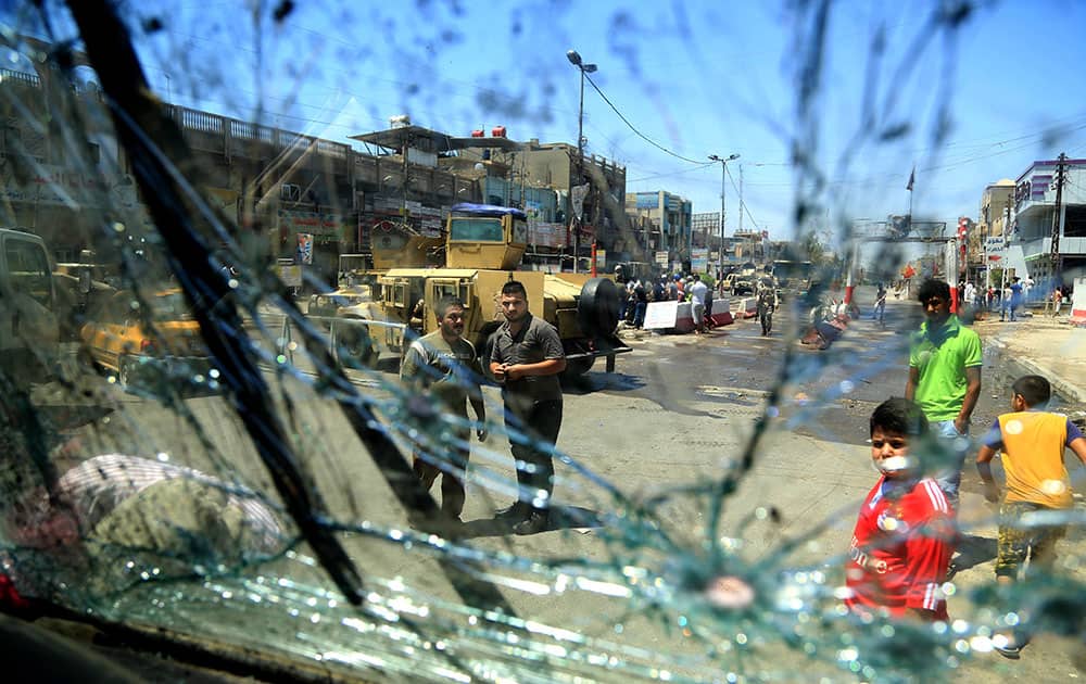 Civilians inspect the aftermath of a bomb attack in the Shiite predominant district of Sadr city, Baghdad, Iraq.