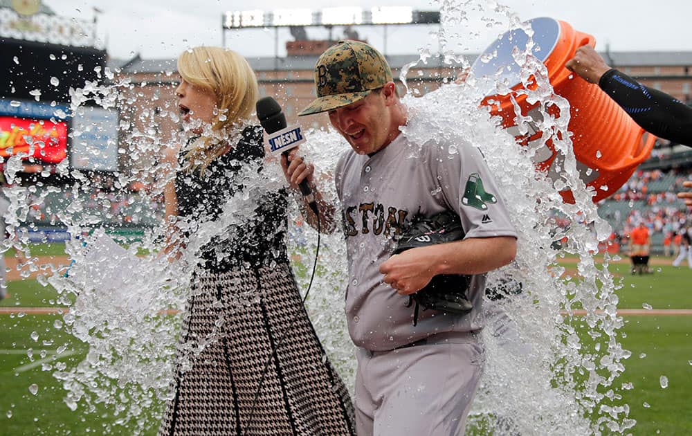 Boston Red Sox starting pitcher Steven Wright, right, is doused by teammates during a post-game television interview after closing out a baseball game against the Baltimore Orioles in Baltimore.