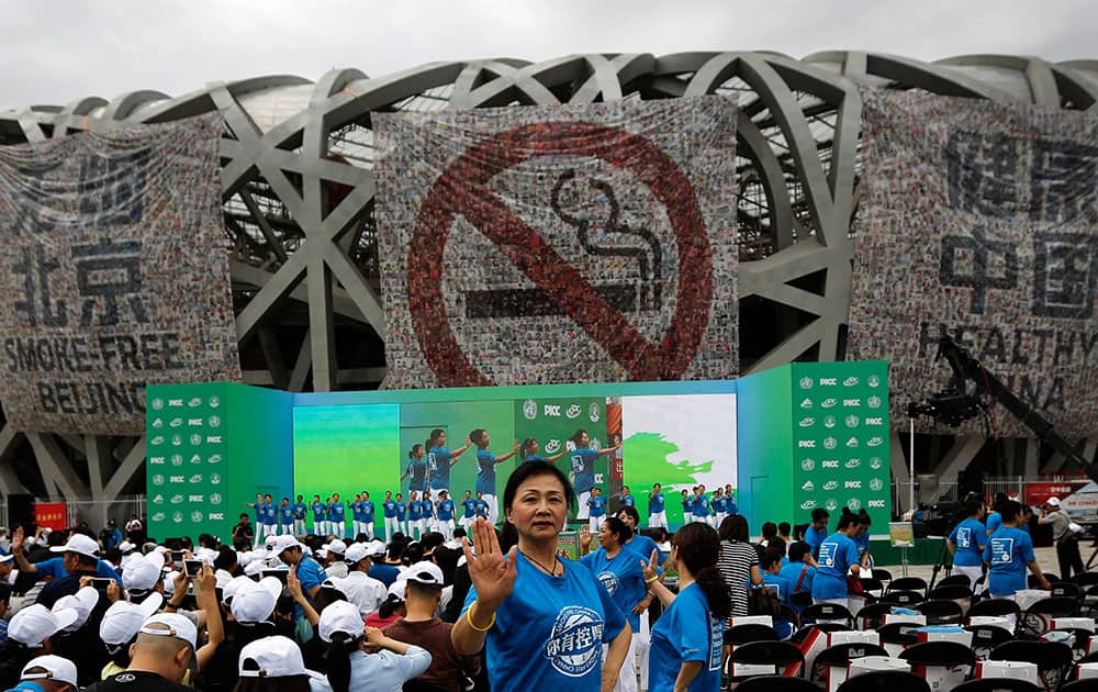 Performers dance in front of anti-smoking banners displayed on the Bird's Nest stadium to mark the World No Tobacco Day in Beijing.