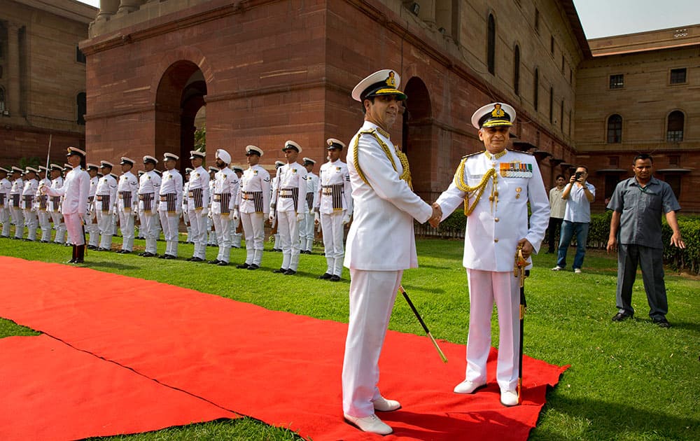 Outgoing Indian Naval Chief Admiral R.K. Dhowan shakes hand with Vice Admiral Sunil Lanba, who took charge as the new Chief of Indian Naval staff, after a ceremonial guard of honor, in New Delhi.