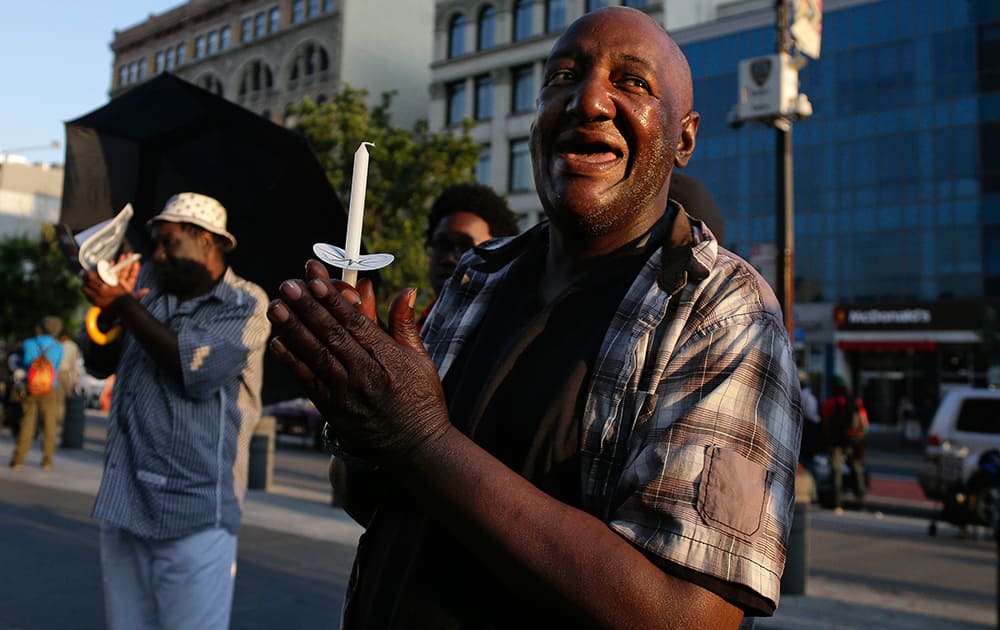 Ronald Blanding, right, applauds as community leaders are introduced at the End Gun Violence Candlelight Vigil in recognition of Gun Violence Awareness Month, in New York. 