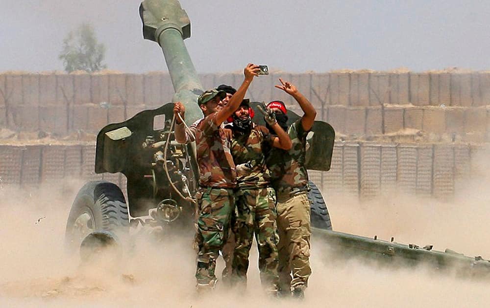 fighters take a selfie while firing artillery during fight against Islamic State militants in Fallujah, Iraq.